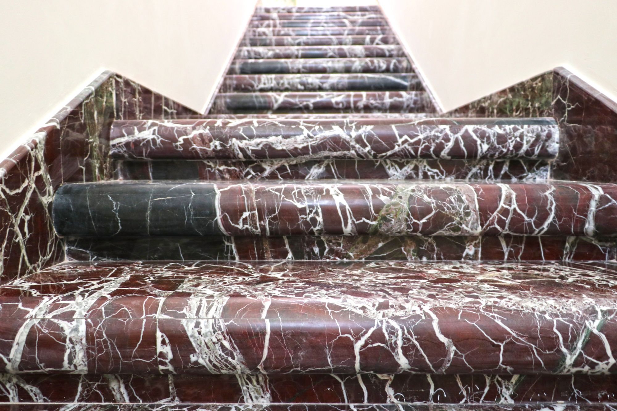 A distinctive staircase made of luxurious Rosso Levanto marble