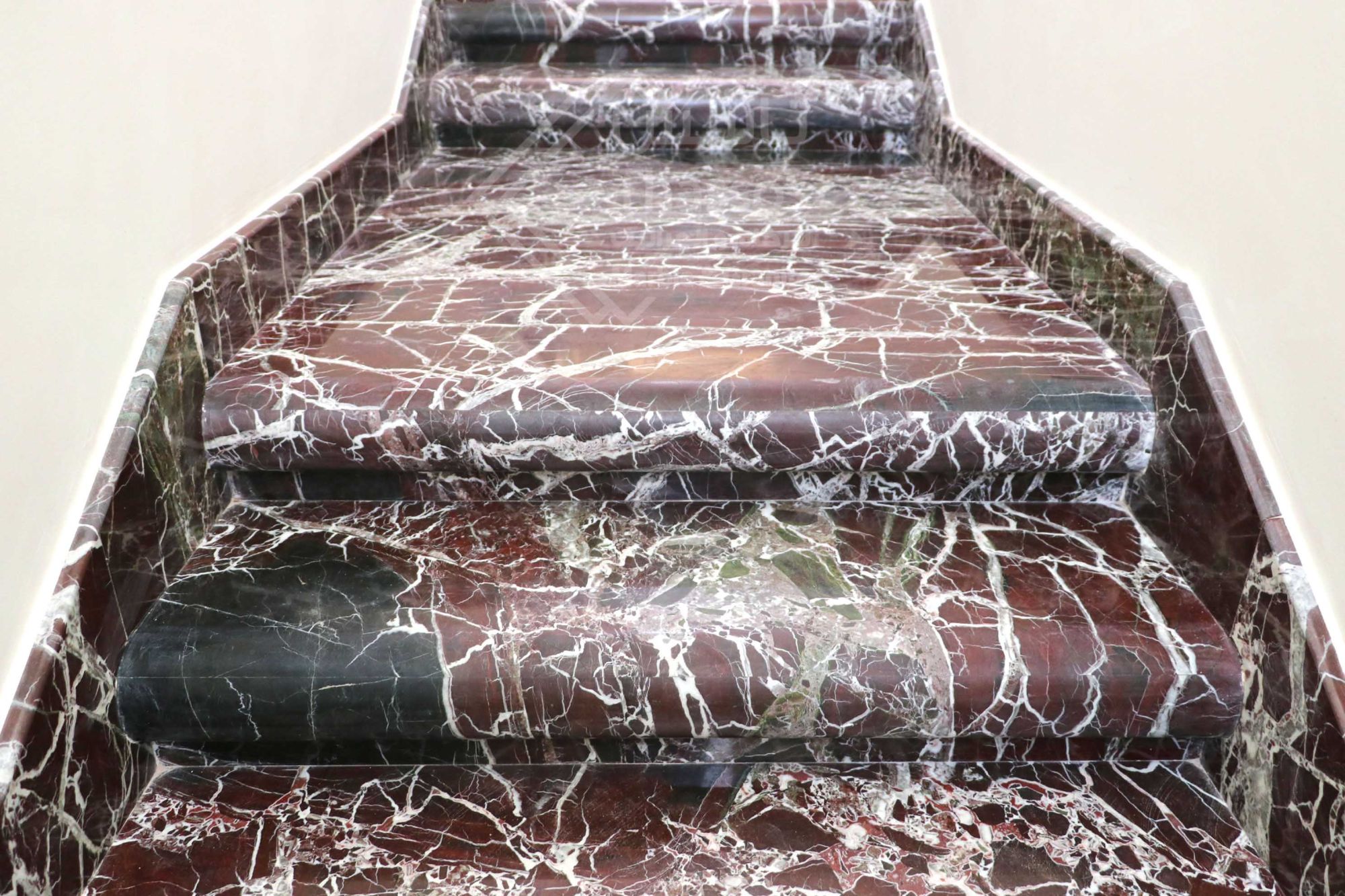 A distinctive staircase made of luxurious Rosso Levanto marble